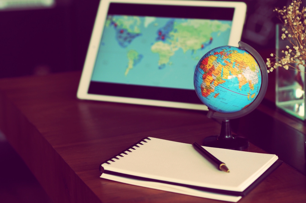 globe ball on table with laptop and notebook,travel concept.