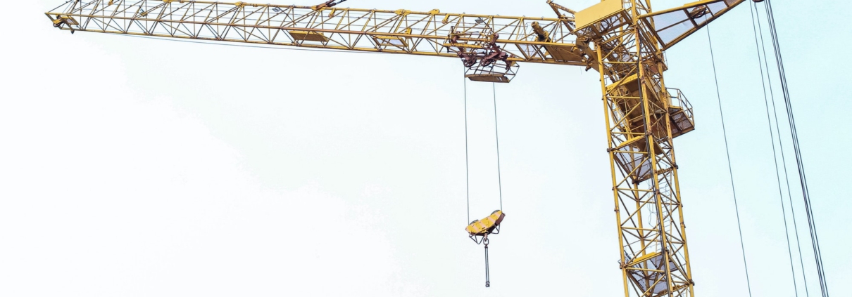 Construction crane stands on the background of the sky. Construction site. Tower crane.