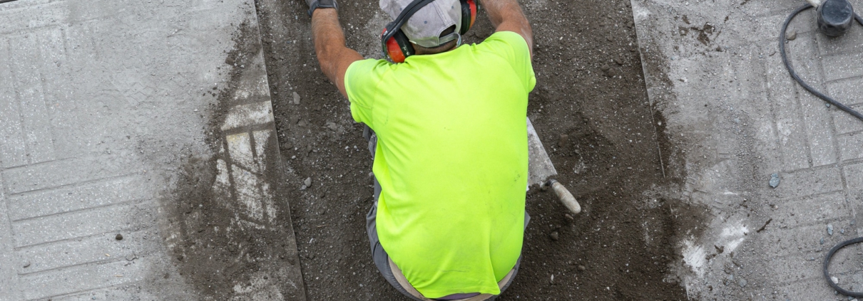 Construction worker with construction level working on a sidewalk