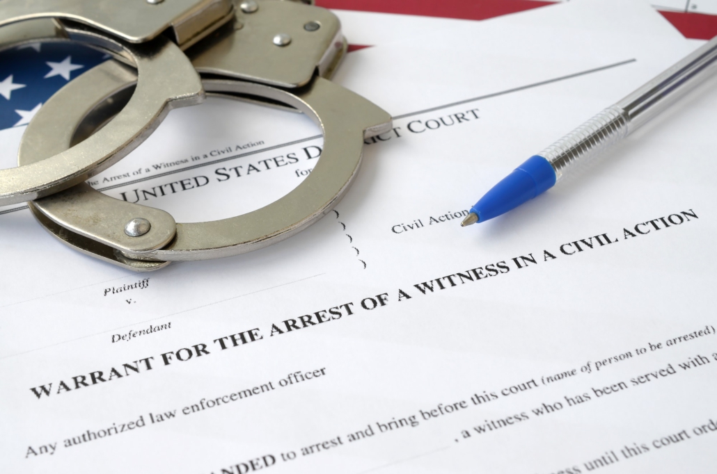District court warrant for the arrest of a witness in a civil action papers with handcuffs and blue