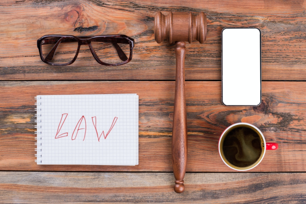 Minimal workspace mobile phone gavel cup of coffee on wood table.