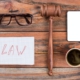 Minimal workspace mobile phone gavel cup of coffee on wood table.