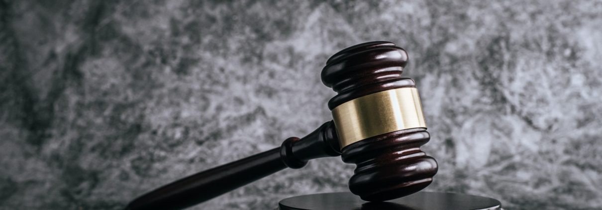 wooden judges gavel on table in a courtroom or enforcement office.