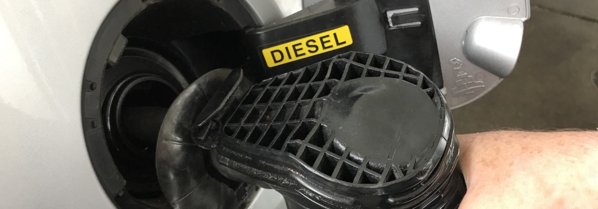 Person filling the car with diesel at the gas station, close-up.
