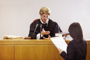 Present your case...Serious young judge sitting in the courtroom with a stern facial expression.